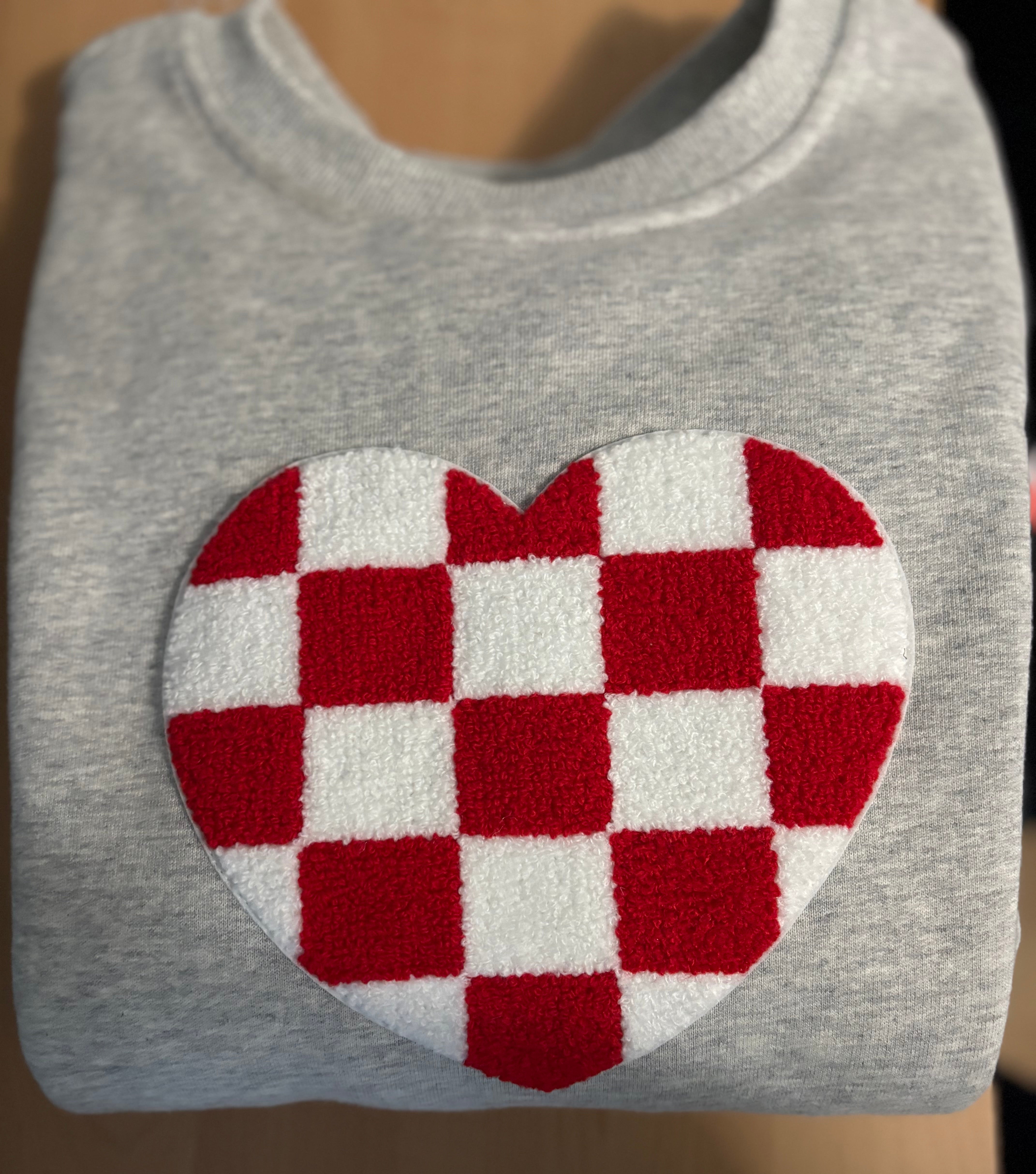 Gray womens Sweater with a red and white checkered heart design on a dark background